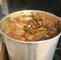 Vegetable scraps in a large pan simmering for stock